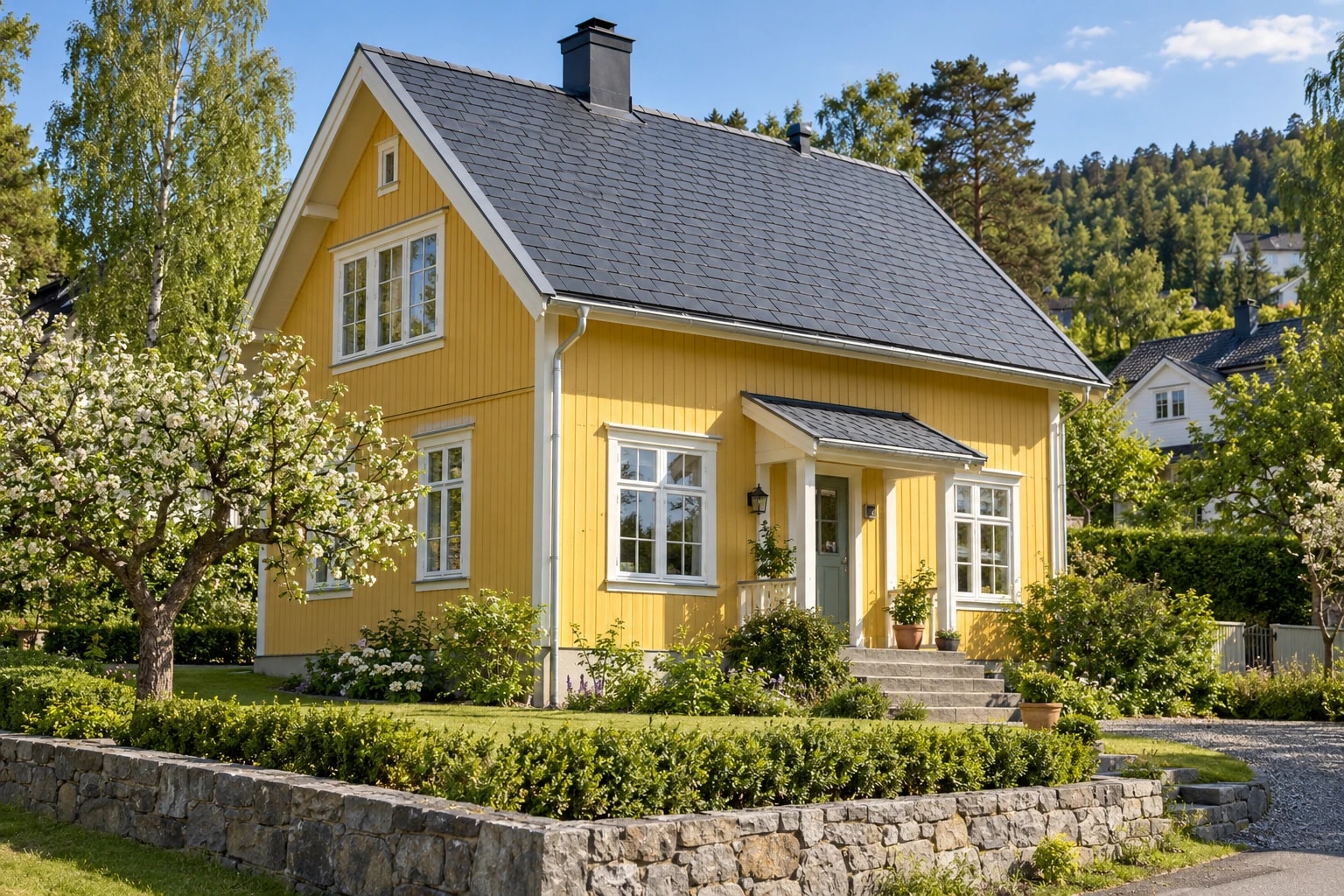 Gul trevilla med skifertak, sinkrenner og synlig nedløp langs fasaden.